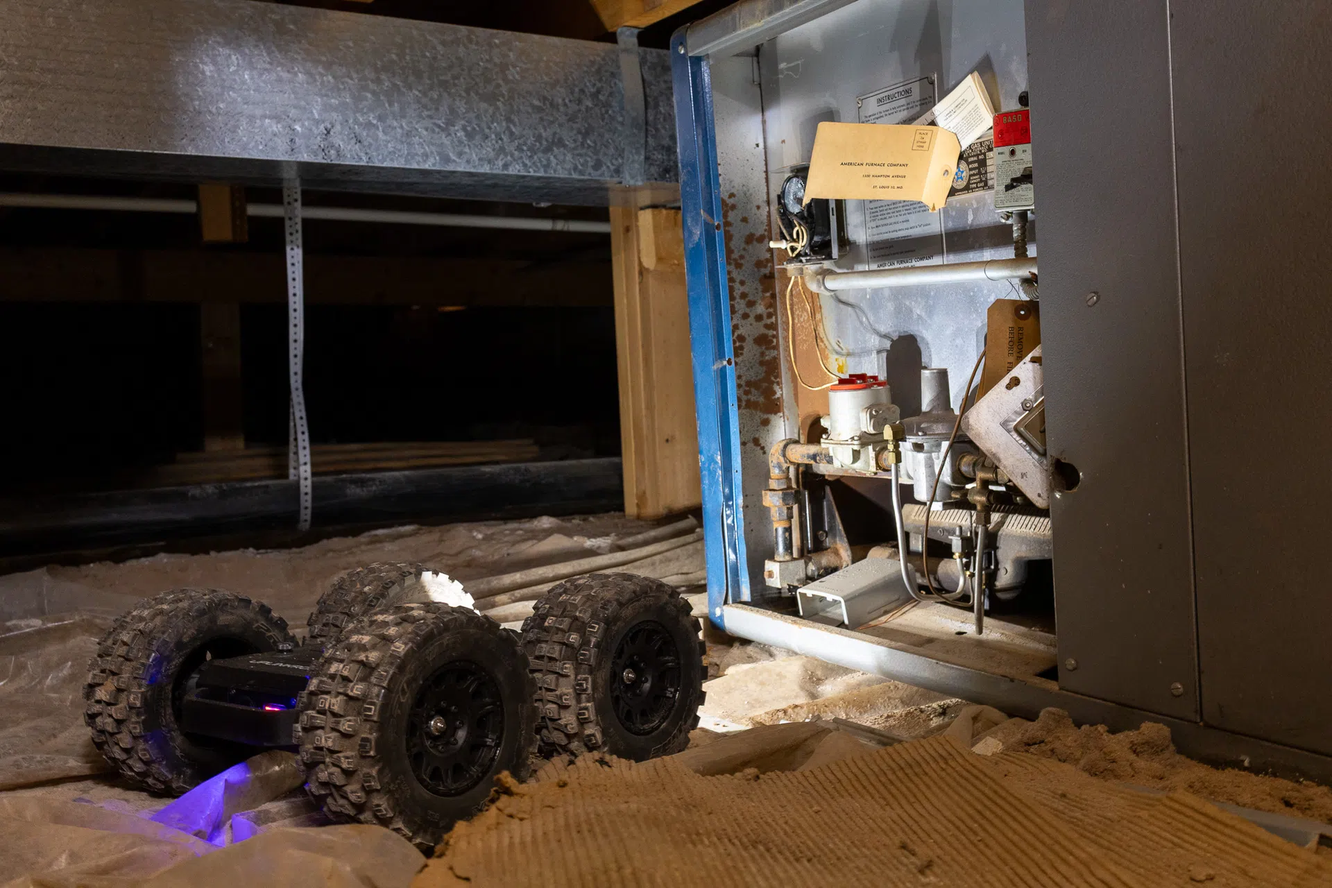 Crawlspace inspection robot near mechanical equipment beneath a home